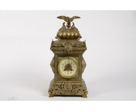 AN ORNATE FRENCH CAST BRASS PILLAR SHAPED MANTEL CLOCK, THE BUN TOPPED CASE WITH FRETWORK BRACKETS AND CRESTED BY AN EAGLE, P
