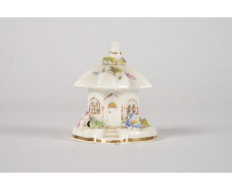 A STAFFORDSHIRE PORCELAIN PASTILLE BURNER IN THE FORM OF A GOTHIC COTTAGE ORNEE, APPLIED AND PAINTED WITH FLOWERS AND CERAMIC