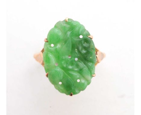 A carved jade ring, the plaque with floral design, in yellow metal mount and shank, ring size O, 3.6g gross.