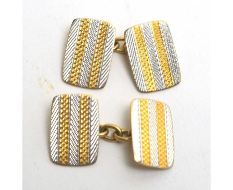 A pair of yellow and white metal cufflinks, with engine turned decoration, each plaque stamped '18ct &amp; Pt' joined by cabl
