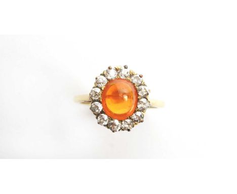 A fire opal and diamond cluster ring, the oval fire opal cabochon measuring 8.8 x 7.7 x 5.8mm (with rounded back), surrounded