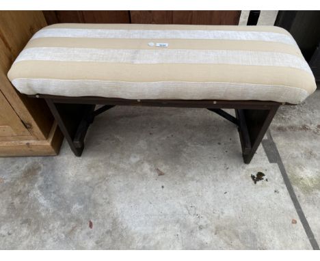 AN UPHOLSTERED BENCH/STOOL ON STAINED WOODEN BASE 