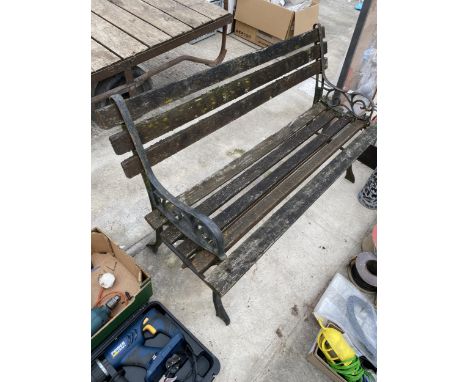 A WOODEN SLATTED GARDEN BENCH WITH CAST BENCH ENDS 