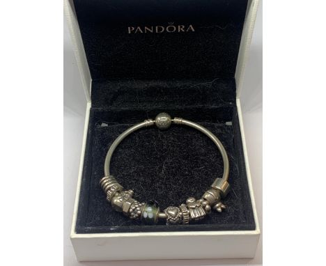 A PANDORA BANGLE WITH WITH TWELVE VARIOUS CHARMS IN A PRESENTATION BOX 