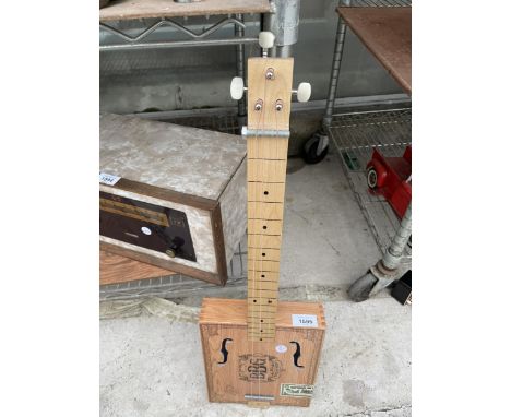 A SCRATCH BUILT THREE STRING INSTRUMENT FORMED FROM A CIGAR BOX 