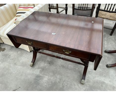 A REGENCY STYLE MAHOGANY SOFA TABLE WITH TWO DRAWERS ON TURNED LEGS, WITH BRASS CLAW FEET AND CASTERS 