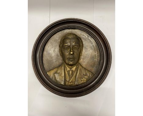 A VINTAGE WOODEN WALL PLAQUE WITH AN IMAGE OF THE RIGHT HON. JOSEPH CHAMBERLAIN (FRED WINTER SCULPTOR), DIAMETER 27CM 