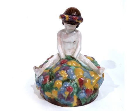 A Vienna werkstatte style ceramic figure, modelled as a child sitting on a floral tuffet, indistinctly signed, 17cm high
