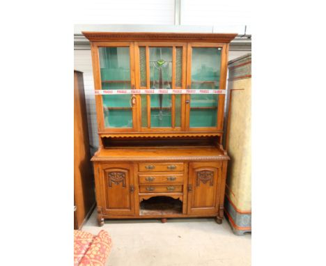 An Art Nouveau oak kitchen dresser, circa 1905, glazed upper section with leaded stylised floral design, opening to shelves, 