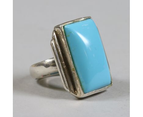 An Art Deco style silver cocktail ring set with a square cushion shaped stone on stepped shoulders. Stamped 925, size R.