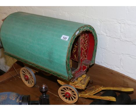 A large model of a gypsy caravan with painted livery and canvas hood.