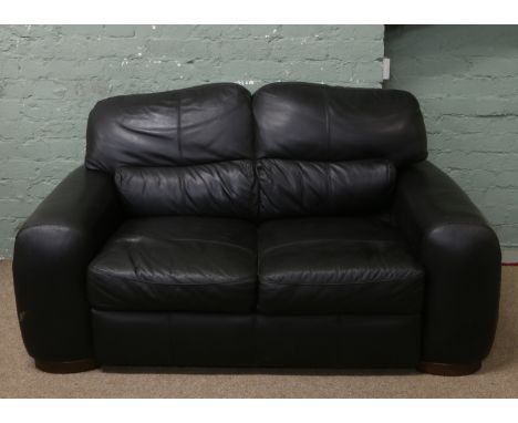 A black leather three piece suite consisting of two seat sofa and two matching reclining arm chairs.