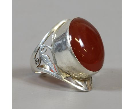 A silver ring with pierced shoulders and set with a large ovoid carnelian, size R.