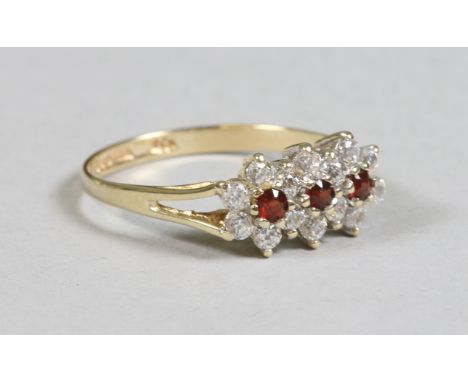 A 9ct gold dress ring set with a red and white stone tripple cluster size M.