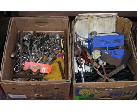 Two boxes of tools including spanners, a battery charger, two boxed brake discs, socket set etc.