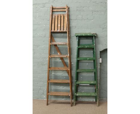 A pair of painted step ladders, along with a similar pair.