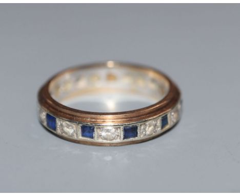 A 9ct yellow and white metal, two colour sapphire eternity ring, size L.