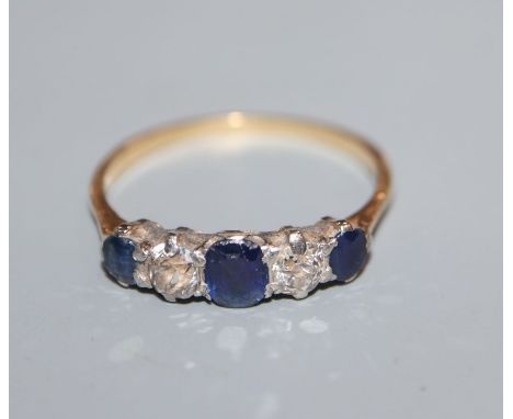 An 18ct, graduated sapphire and diamond five stone half hoop ring, size P.