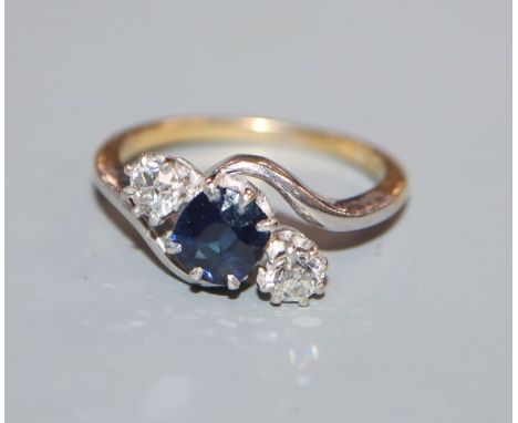 An 18ct, sapphire and diamond three stone crossover ring, size K.