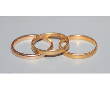 A 22ct gold wedding ring, an 18ct gold wedding ring and a yellow metal wedding ring.