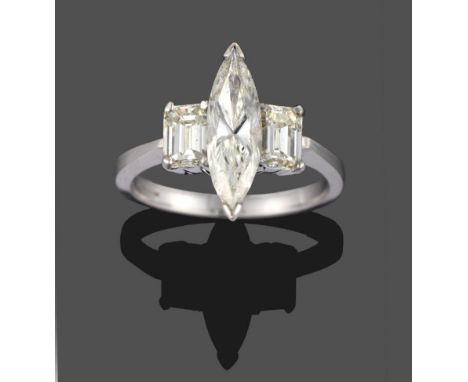 An 18 Carat White Gold Diamond Three Stone Ring, a marquise cut diamond centrally with an emerald cut diamond to each side, i