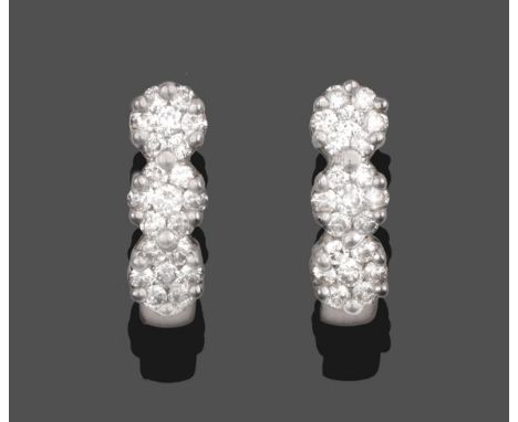 A Pair of 18 Carat White Gold Diamond Earrings, a row of three clusters of round brilliant cut diamonds in claw settings, wit
