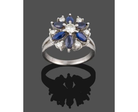 A Sapphire and Diamond Cluster Ring, a round brilliant cut diamond centres a cluster of six marquise cut sapphires, a smaller