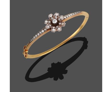 A Diamond Set Bangle, circa 1900, old cut diamonds set to form a flowerhead, which sits atop a tapering bangle, the facing se