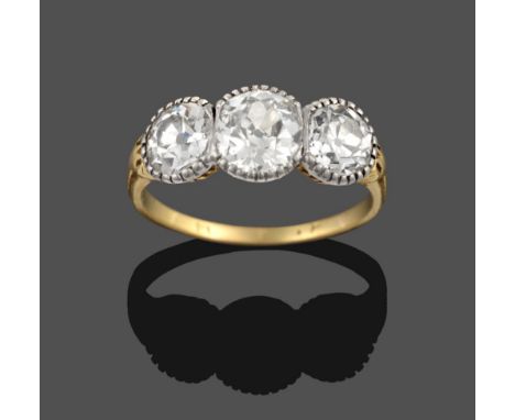 An Early 20th Century Diamond Three Stone Ring, the graduated old cut diamonds in white fronted claw settings, on yellow moun