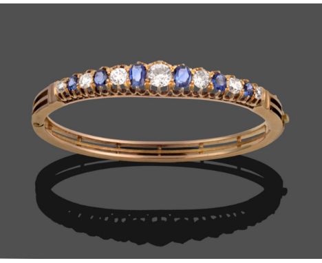 A Sapphire and Diamond Bangle, circa 1880, six graduated oval cut sapphires alternate with seven old cut diamonds, in yellow 