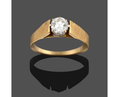 A Diamond Solitaire Ring, the round brilliant cut diamond in a white claw setting, to a textured tapered shoulder plain polis