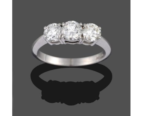 An 18 Carat White Gold Diamond Three Stone Ring, the round brilliant cut diamonds in claw settings, to a tapered shoulder pla