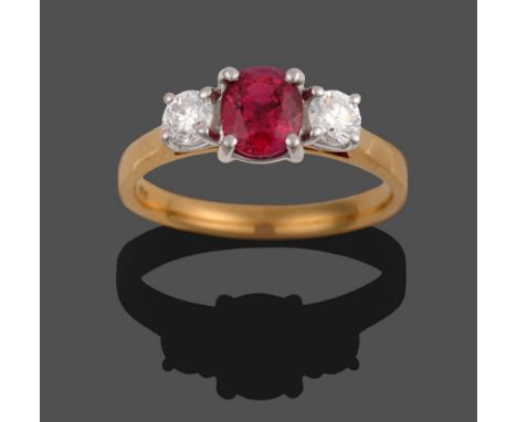 An 18 Carat Gold Ruby and Diamond Three Stone Ring, the oval mixed cut ruby flanked by two round brilliant cut diamonds in wh