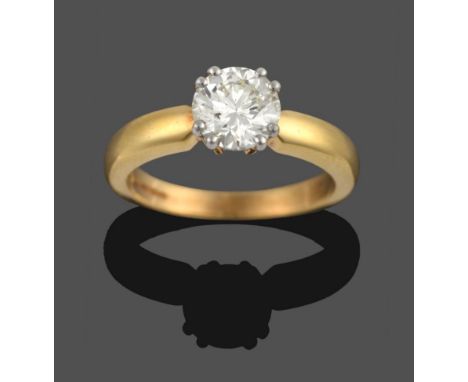 An 18 Carat Gold Diamond Solitaire Ring, the round brilliant cut diamond in a white claw setting on pointed yellow shoulders 
