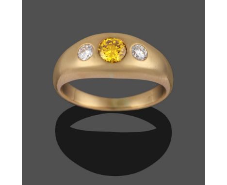 A Diamond Three Stone Ring, the graduated round brilliant cut diamonds drill set with a (treated) yellow diamond to the centr