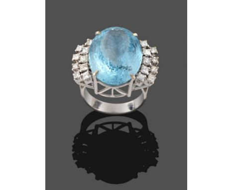 An Aquamarine and Diamond Ring, the oval cut aquamarine in a white four claw setting, with nine princess cut diamonds set to 
