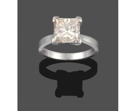 A Platinum Diamond Solitaire Ring, the princess cut diamond in a four claw setting to knife edge shoulders on a plain polishe