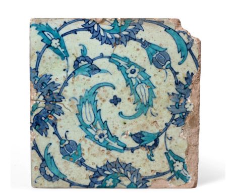 A Damascus Pottery Tile, early 17th century, painted in blue and turquoise with stylised spiralling tulips, 25cm by 25cm.  On