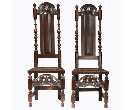 Each with a slender arched and fielded back panel, below an arched double-C and scroll carved and pierced cresting, flanked b