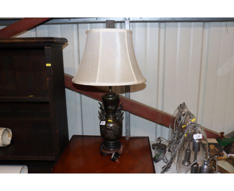 An Oriental bronzed table lamp with bird and floral decoration 