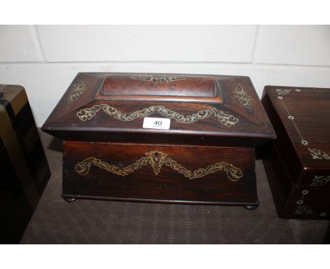 A 19th Century rosewood tea caddy of sarcophagus form with mother of pearl inlay, flanked by turned handles