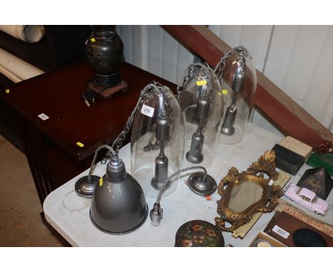 Three Jim Lawrence pendant lights with glass shades; and a Jim Lawrence metal pendant light and another
