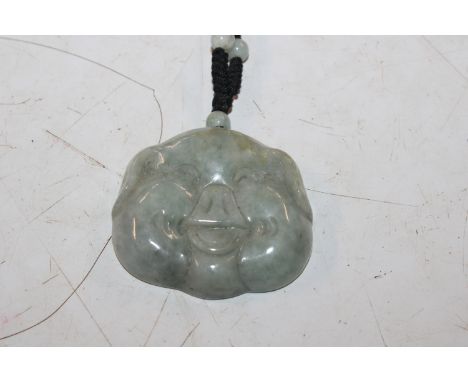 A Chinese jade lucky pig necklace on silk chord 