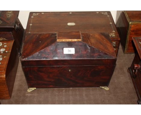 An antique mahogany two compartment tea caddy of sarcophagus form, flanked by lion mask ring handles and raised on claw suppo
