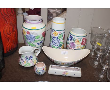 Seven items of Poole pottery typically decorated with colourful flowers 