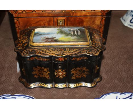A Victorian papier mâché tea caddy, the lid having mother of pearl inlay and painted panel depicting figures fishing