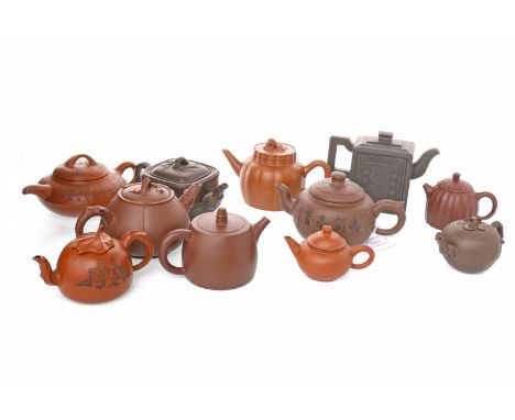 COLLECTION OF ELEVEN YIXING CERAMIC TEAPOTSof various round and square forms, the tallest 11cm high