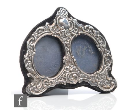 A hallmarked silver easel photograph frame with two oval apertures within an embossed foliate design, height 10cm, London 198