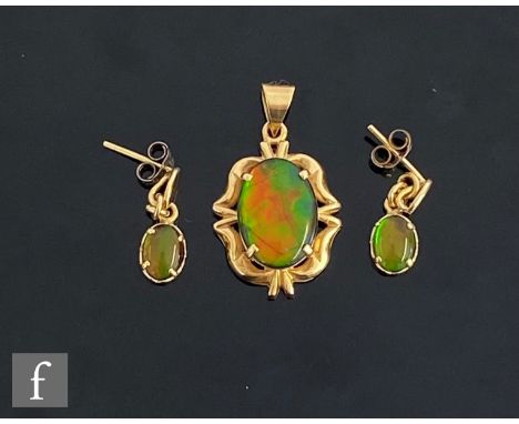 An 18ct opal doublet pendant, oval stone within an gold border, with a matching pair of drop earrings, total weight 5.4g. (2)