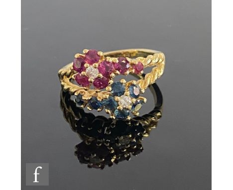 An 18ct double head cluster ring comprising a ruby and diamond and a sapphire and diamond cluster each to a split rope twist 